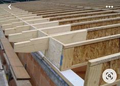 some wooden boards are stacked on top of each other in the middle of an assembly line