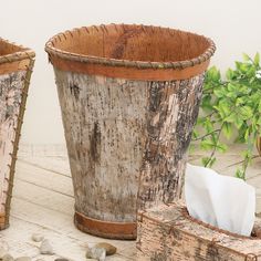 two wooden buckets sitting next to each other on top of a white table with rocks