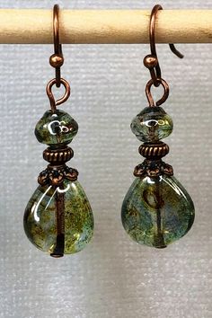 Gorgeous green dangle Czech glass earrings with hints of brown and a special luster. Best Seller! Unique Green Teardrop Beaded Earrings, Green Czech Glass Teardrop Jewelry, Green Teardrop Czech Glass Jewelry, Bohemian Teardrop Glass Jewelry, Teardrop Czech Glass Dangling Beads Earrings, Green Teardrop Glass Jewelry, Czech Glass Teardrop Earrings With Ear Wire, Handmade Czech Glass Teardrop Earrings, Beaded Glass Teardrop Earrings