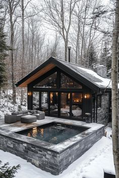 an outdoor hot tub surrounded by snow and trees