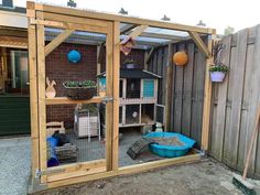 a small backyard with a chicken coop and various items in the back yard, as well as a cat house