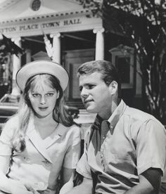 black and white photograph of man and woman in front of building