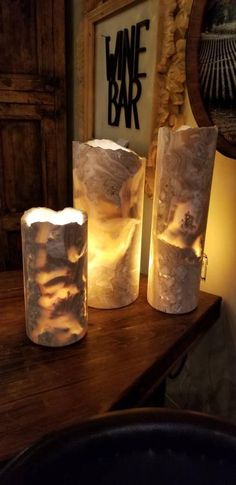 three lit candles sitting on top of a wooden table