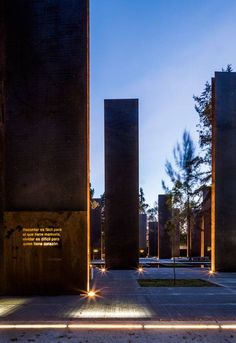 three tall concrete pillars with lights on them