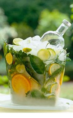 a pitcher filled with lemons, cucumbers and limeade sitting on top of a table