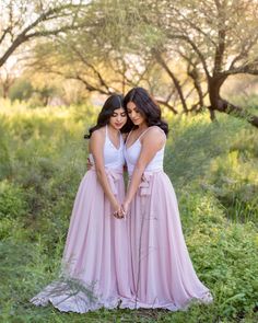 two women in long dresses standing next to each other