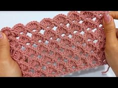 someone is crocheting the edge of a piece of pink yarn with their hands