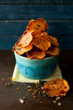 a blue bowl filled with potato chips on top of a table