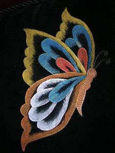 an embroidered butterfly on a black background