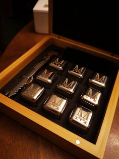 a wooden box filled with metal letters on top of a table