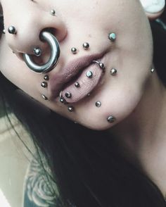 a woman with piercings on her face and nose