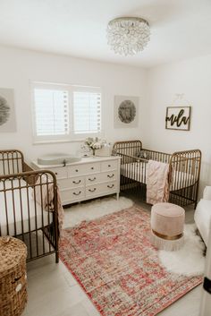 a baby's room with two cribs and a rug on the floor