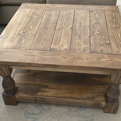 a wooden coffee table sitting on top of a carpeted floor next to a couch