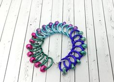 a bracelet made out of colorful beads on a white wooden floor with wood planks in the background