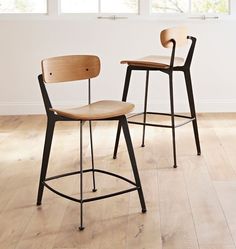 two stools sitting on top of a hard wood floor in front of a window