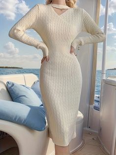 a woman in a white sweater dress standing on the back of a boat with her hands on her hips