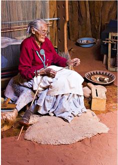 an old woman sitting in front of a weaving machine