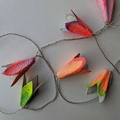 paper flowers are tied up on a string