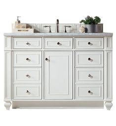 a white bathroom vanity with two sinks and drawers