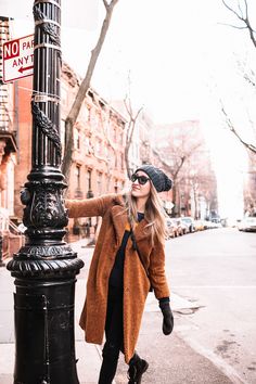 a woman standing next to a street light