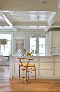 a large kitchen with white cabinets and wooden flooring, along with a breakfast nook