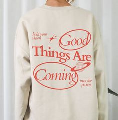 Manifest good vibes with our 'Good Things Are Coming' Crewneck, the Y2K sweatshirt turned affirmation graphic pullover. Trust the process and stand out with this trendy vintage inspired shirt! 🫧 SIZING * Unisex crewneck, classic fit (Gildan 18000) * Available sizes: S -5XL (unisex size) * Refer to the size chart in the photos for details 🫧 MATERIALS * 50% Cotton; 50% Polyester 🫧 CARE * Machine wash cold, inside-out, gentle cycle with mild detergent and like colors * Tumble dry on a low cycle Spring Sweatshirt With Graphic Print And Drop Shoulder, Drop Shoulder Graphic Print Sweatshirt For Spring, Spring Drop Shoulder Sweatshirt With Graphic Print, Lettering Sweatshirt For Spring Streetwear, Spring Lettering Sweatshirt Relaxed Fit, Relaxed Fit Lettering Sweatshirt For Spring, Relaxed Fit Sweatshirt With Lettering For Spring, Oversized Slogan Crew Sweatshirt, Spring Graphic Tee Sweatshirt With Letter Print