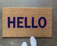 someone standing in front of a door mat that says hello