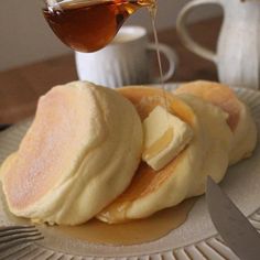 a plate topped with pancakes covered in butter and syrup