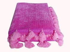 a pink blanket with tassels on it