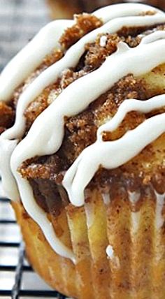 a muffin with white icing sitting on top of a cooling rack