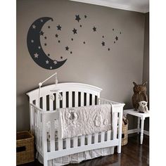 a baby's room with a white crib and stars on the wall