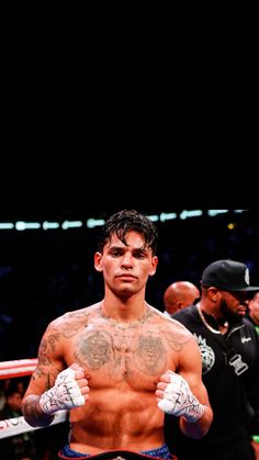 a shirtless man standing in the middle of a boxing ring with his hands on his hips