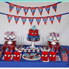 a spiderman birthday party with cake, cupcakes and desserts on the table