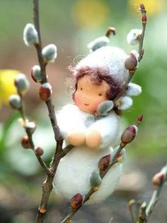 a doll sitting on top of a tree branch