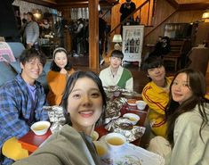 a group of people sitting at a table with food and drinks in front of them