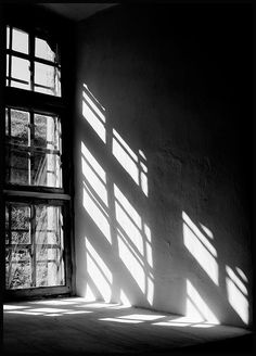 black and white photo of sunlight coming through windows