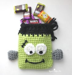 a crocheted bag with candy and candies in it's mouth, on top of a table