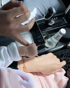 two hands on the arm of a doll in a car