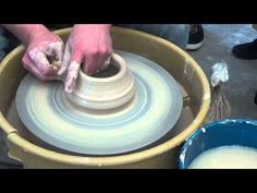 a person is making a pot on a potter's wheel with one hand and the other