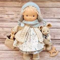 a doll and two stuffed animals on a wooden surface