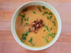 a white bowl filled with soup on top of a wooden table