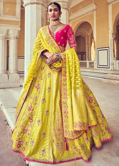 Woven Zari Banarasi silk lehenga choli in Yellow and Pink 6002 Desc:  Style : A-Line Lehenga Choli Color : Yellow and Pink Fabric : Silk   Work : Heavy Jacquard Woven With Embroidery & Stone Work Wash Care : Dry clean Sleeve Style : Half Sleeve Long Sleeves : Done only in Custom Stitch Sleeves Lining : Done only in Custom Stitch Bust Size : 32 to 42 Inches Occasion : Wedding   Mehendi   Sangeet   Engagement   Reception   Ceremonial   Baby ShowerShop Banarasi lehenga,silk lehengas,h Yellow Lehenga Designs, Lemon Yellow Lehenga, Bandhani Suit, Blouse Lehenga, Ghaghra Choli, Mirror Work Lehenga, Silk Lehenga Choli, Diwali Outfits, Yellow Lehenga