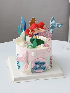 a birthday cake with a little mermaid on top