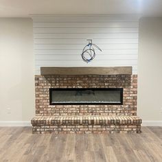 an empty living room with a brick fireplace