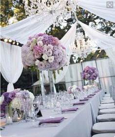 an image of a table set up for a wedding reception with flowers and candles on it