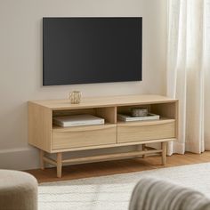 a flat screen tv mounted to the side of a wooden entertainment center in a living room