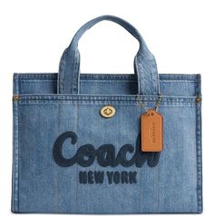 An ode to classic blue jeans, this tote by COACH is crafted in denim with leather accents and features a zippered closure for easy and secure access to your belongings. Medium sized bag; 13-1/2"W x 10"H x 6-1/4"D (width is measured across the bottom of handbag); 1.98 lbs. approx. weight • Silhouette is based off 5'9" model • 4-1/2"L handles; 24"L removable strap • Zippered closure • Brass-tone hardware, embroidered logo, exterior turn-lock & snap pockets & luggage tag • Laptop compatible (std. size 13"") • Denim, leather • Spot clean Includes dust bag Style num CR657 Coach Denim, Denim Cargo, Coach New York, Denim Tote Bags, Denim Tote, Women Cargos, Medium Tote, Denim Bag, Coach Bag