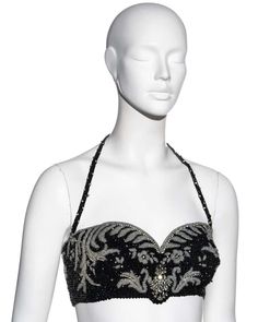 For Sale on 1stDibs - ▪ Gianni Versace silk corset bra ▪ Fully beaded with black and clear beads ▪ Crystal embellishment ▪ Halterneck ▪ Hook fastenings at centre back ▪ IT 42 Black Fitted Bodice For Party, Embellished Evening Corset With Fitted Bodice, Strapless Embellished Evening Corset, Embellished Corset With Fitted Bodice For Evening, Elegant Black Bodice For Party, Glamorous Embellished Evening Corset, Black Strapless Evening Bodice, Black Strapless Bodice For Evening, Black Boned Bodice For Evening Wear