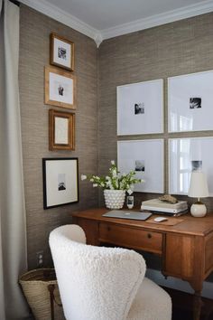 a wooden desk topped with a white chair next to pictures on the wall above it