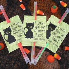 three halloween stickers with black cats on them and candy sticks in front of them